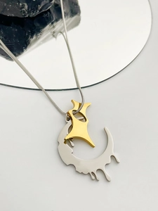 Detailed macro of silver snake chain with gold star and silver crescent pendants
