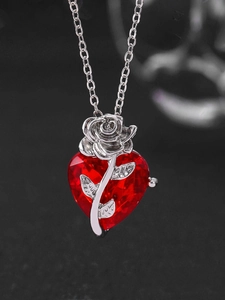 Detailed close-up of a red heart crystal necklace with an elegant silver rose overlay