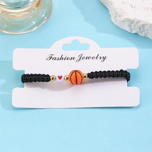 Detail van handgeweven basketbalarmband met hartkraal op een presentatiekaartje