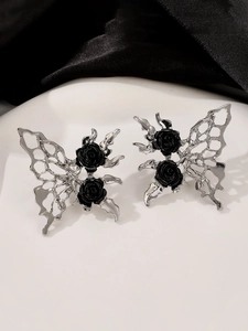 Macro detail of silver butterfly earrings with black roses and delicate crystal accents