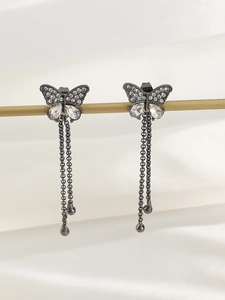 Close-up of sparkling butterfly tassel earrings featuring white crystals and long chain fringes
