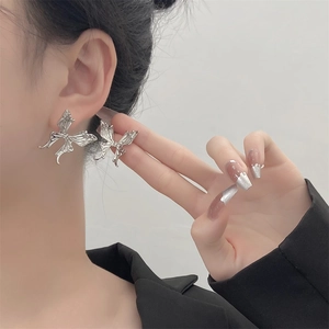 Silver hollow butterfly stud earrings with liquid metal design worn on female model