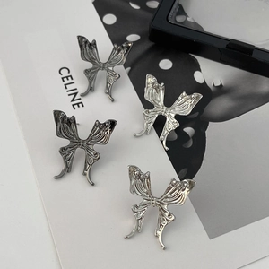 Detailed view of silver butterfly stud earrings with vintage brushed metal texture finish
