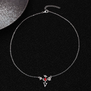 Detail view of silver O-chain necklace with a gothic thorn frame and red zircon pendant
