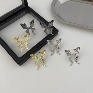Detailed macro shot of rhinestone hollow butterfly earrings in gold, silver, and black metal