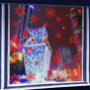 Dettaglio degli adesivi rossi a forma di fiocco di neve per decorazione vetrine natalizie