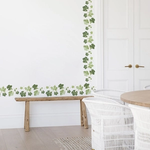 Detail of green leaf vine wall stickers made of PVC on a clean white interior wall
