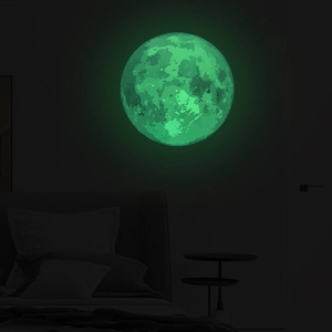 Detailed macro view of luminous moon wall sticker with green fluorescent glow in bedroom