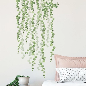 Detail of green watercolor succulent vine wall stickers hanging on a white bedroom wall