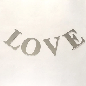 Macro detail of silver acrylic mirror wall stickers forming the word LOVE for home decor