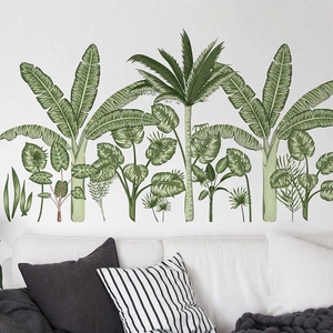 Tropical wall stickers featuring green palm and banana leaves over a white sofa