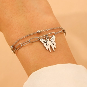 Detail of silver double-layered chain bracelet with paperclip links and butterfly charm
