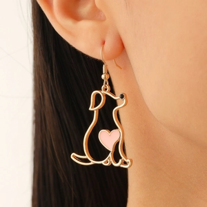 Nahaufnahme eines goldenen Hunde-Ohrrings mit rosa Herz am Model-Ohr getragen