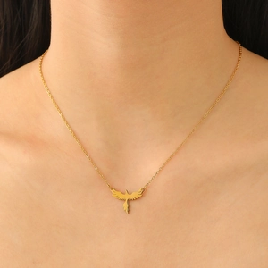 Close-up of a golden eagle pendant necklace in shiny finish worn on a model's neck