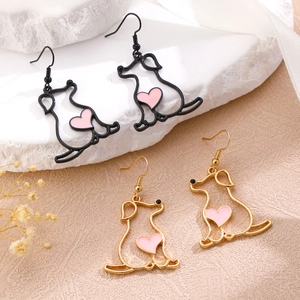 Detail von süßen Hunde-Ohrringen mit rosa Herz-Anhängern in Schwarz und Gold-Finish