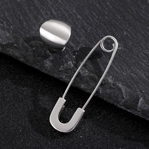 Polished silver safety pin earrings set on a dark textured stone background