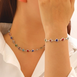 Détail de l'ensemble collier et bracelet avec cristaux de cœur colorés sur modèle