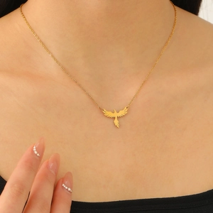Close-up of golden eagle pendant necklace worn on neck with detailed spreading wings
