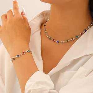 Vue détaillée du collier et bracelet à cristaux colorés en forme de cœur sur femme