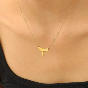 Close-up of golden eagle pendant necklace with intricate hollow design on model
