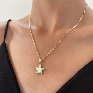 Detailed view of a gold star pendant with white inlay on a minimalist chain necklace