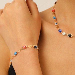 Détails des perles mauvais œil et disques creux sur une parure de bijoux dorée chic