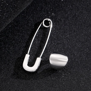 Polished silver paperclip earring and smooth ear cuff set on a dark textured background