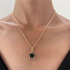 Elegant gold star pendant necklace with black enamel inlay on a refined dainty chain