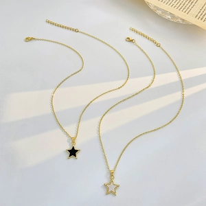 Detailed close-up of two gold star pendant necklaces with black and white fillings