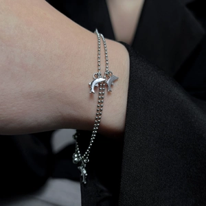 Detail of silver double-layered bead chain bracelet with dolphin charms on wrist