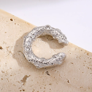 Macro shot of silver lava textured hoop earring with inlaid cubic zirconia crystals