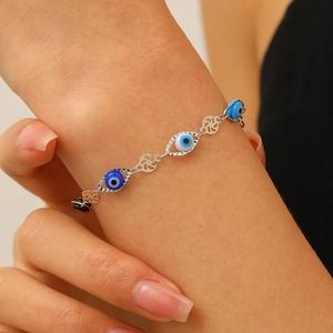 Gros plan détaillé d'un bracelet chaîne en argent avec perles mauvais œil et breloques