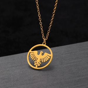 Detailed macro view of a gold eagle pendant with intricate circular hollow frame design