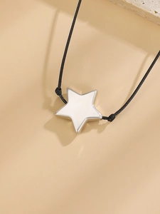 Detailed view of minimalist white enamel star pendant necklace with sleek black cord