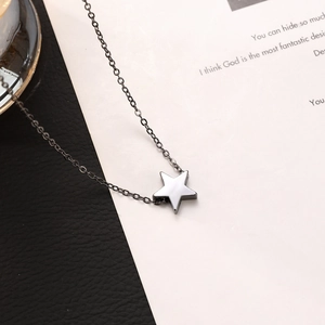 Close-up of a silver starfish pendant necklace on a textured black leather background