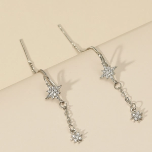 Detailed shot of silver tassel drop earrings with octagonal star and white zircons