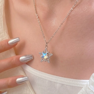 Detail of minimalist star pendant necklace with shimmering inlay and pave crystals