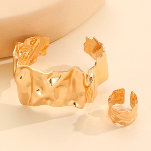 Detailed macro view of gold liquid metal leaf bracelet and ring set with wrinkled texture