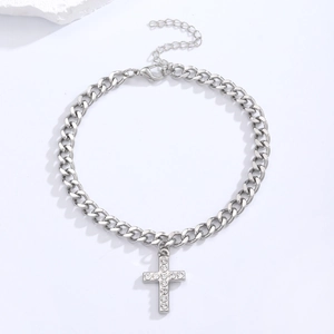 Detail view of silver curb chain necklace with sparkling rhinestone cross pendant