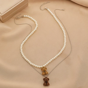 Dettaglio collana a doppio strato con orsetti floccati marroni e perle finte bianche