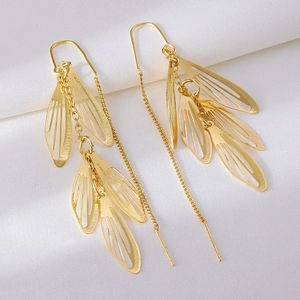 Elegant gold S925 leaf tassel earrings with hollow filigree design on white satin