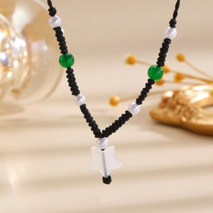 Detailed shot of handmade woven necklace featuring green beads and a star pendant