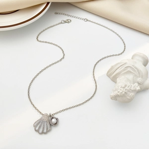 Macro detail of mermaid shell pearl pendant with cubic zirconia on silver chain