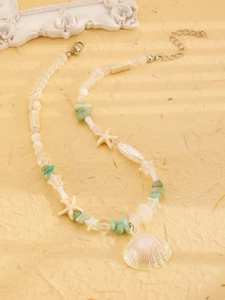 Detail of beaded necklace with starfish accents and iridescent shell pendant on beige paper