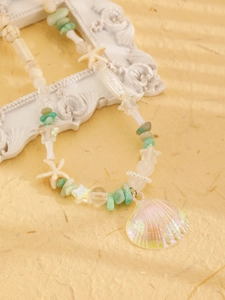 Detailed shot of mermaid shell pendant with sea star beads and natural green stones