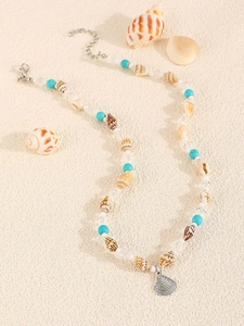 Detailed macro view of mermaid shell pendant necklace with turquoise beads and pearls