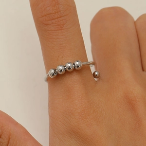 Detailed view of silver anxiety ring with five movable beads worn on finger