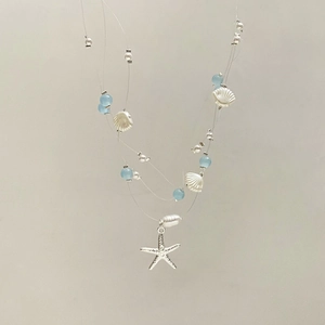 Detail of multi-layer ocean necklace with starfish charm and white shell accents