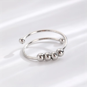 Detailed macro view of the silver rotating anti-anxiety ring with four movable metal beads
