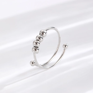 Macro detail of silver anti-anxiety fidget ring with rotating beads on a white surface